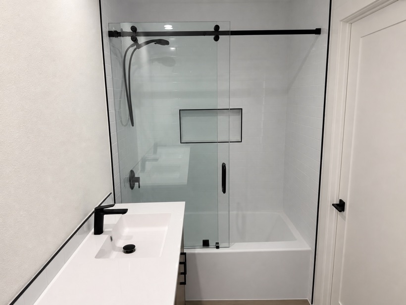 Modern bathroom with vanity, tub and frameless glass shower