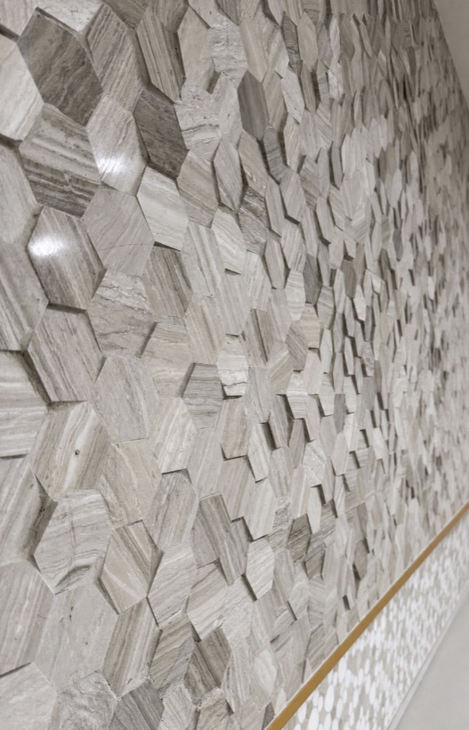 Dimensional three-dimensional carved marble hexagon mosaic feature wall with brass trim