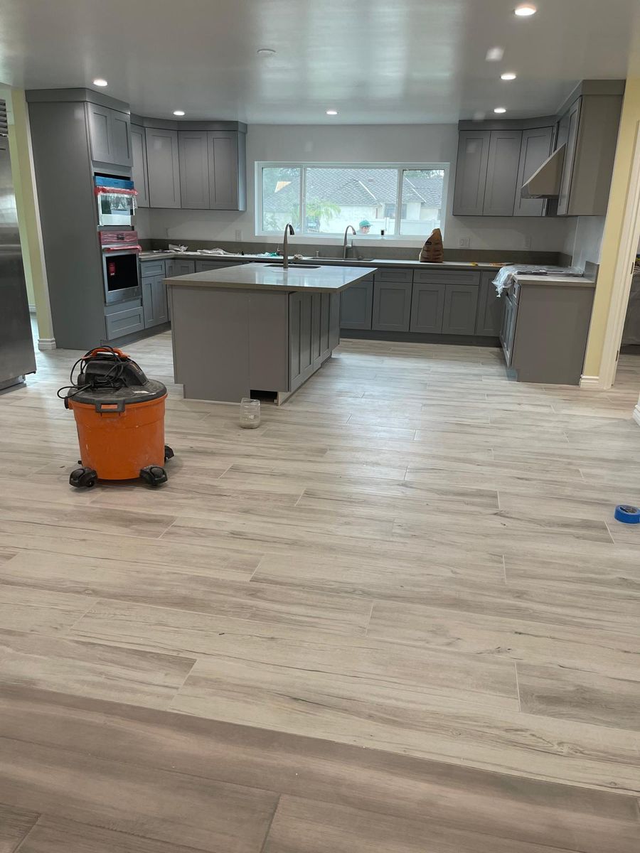 Wide-plank wood-look flooring running through an open kitchen and living area