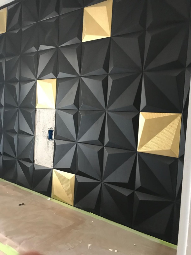 Matte black dimensional pyramid tile wall with brass accent tiles