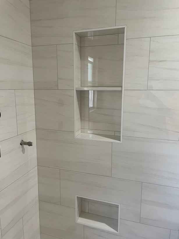 White marble shower wall with stacked recessed niches